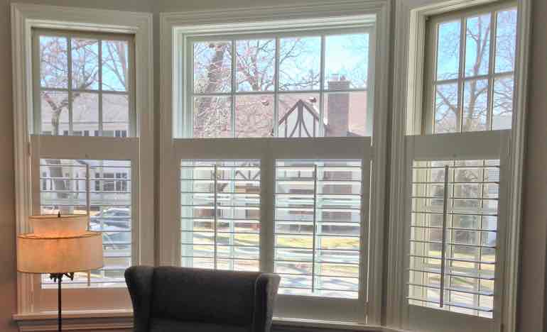 Half white shutters in family room bay window.